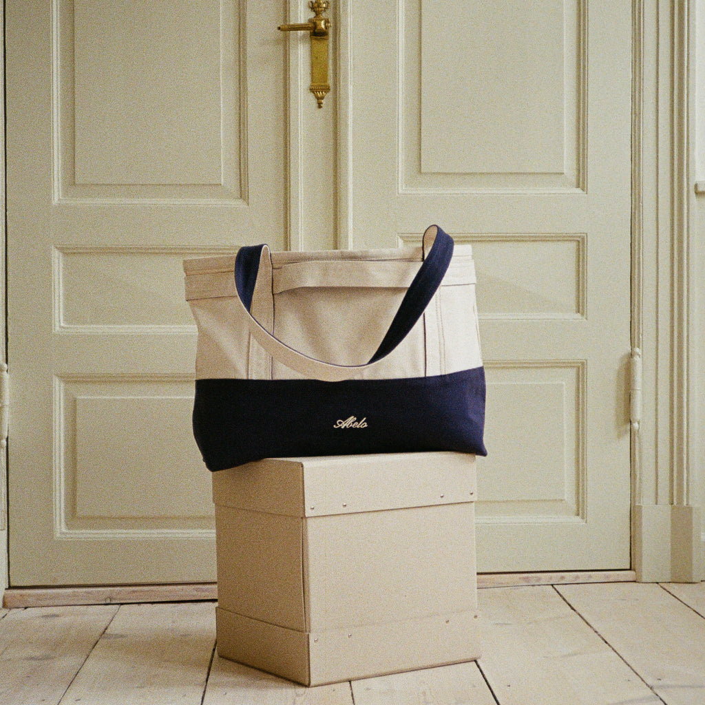 Babette's Travel Bag in beige and navy, back view with Abelo embroidery