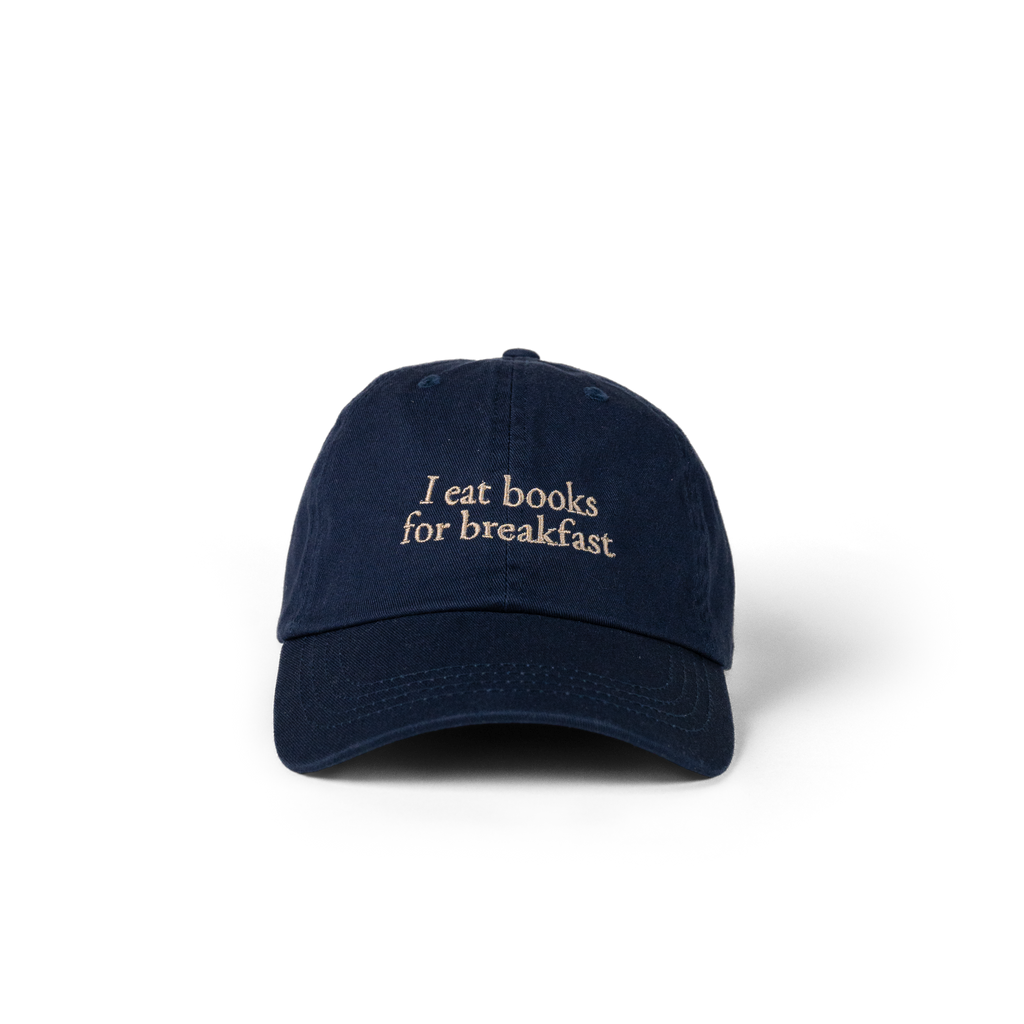 The Eye Cap in navy with 'I eat books for breakfast' embroidered on the front