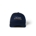 The Eye Cap in navy with 'I eat books for breakfast' embroidered on the front