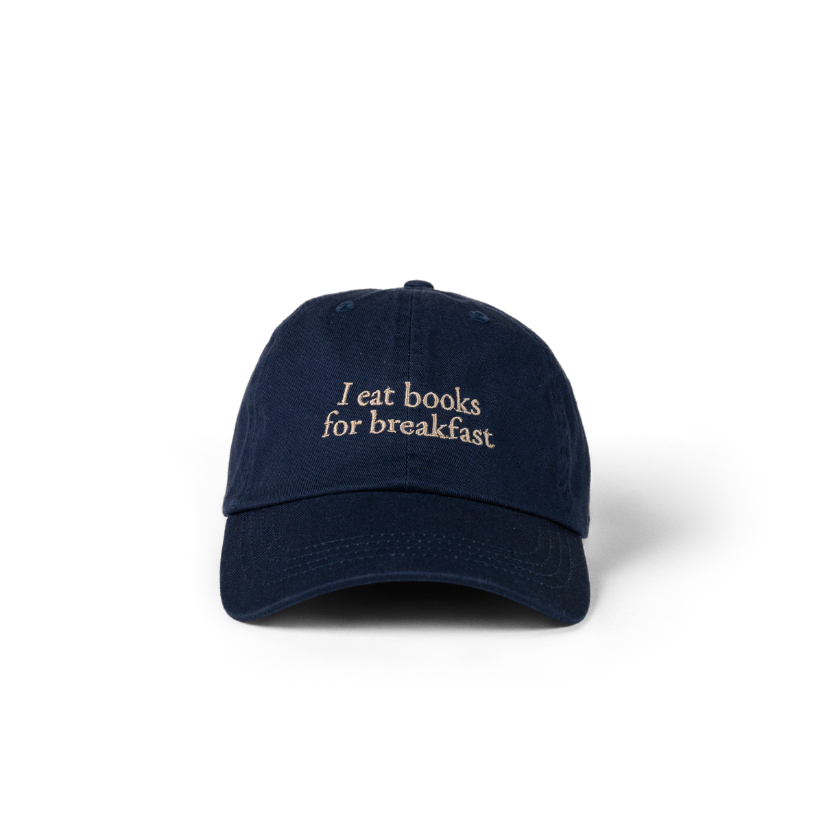 The Eye Cap in navy with 'I eat books for breakfast' embroidered on the front