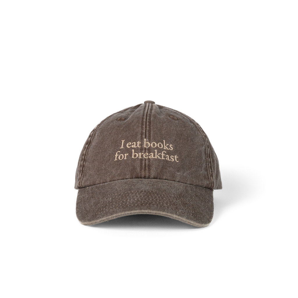 Laughter in the Dark Cap in washed brown with 'I eat books for breakfast' embroidered on the front
