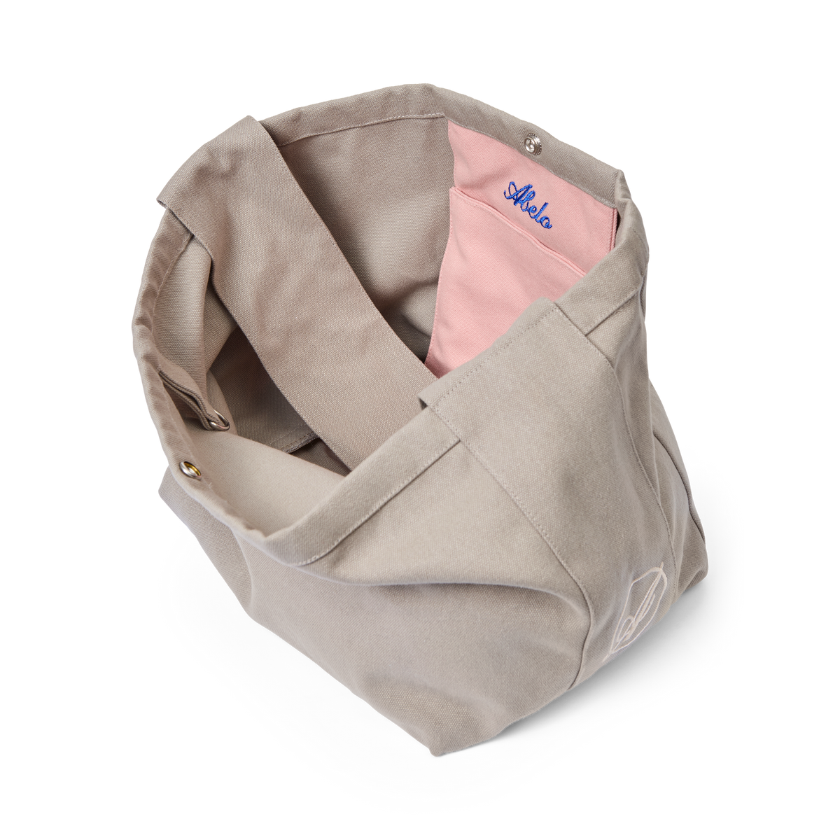 Some Rain Must Fall Extra Bag seen from above, showing the pink interior pocket with Abelo embroidery